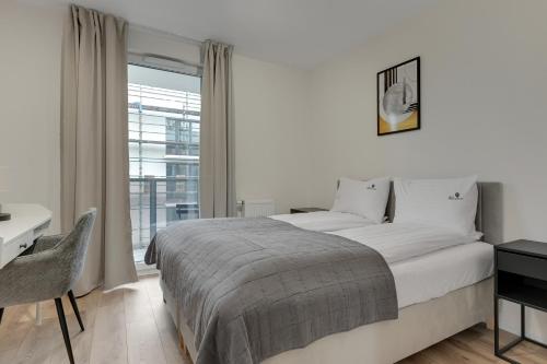 Ένα ή περισσότερα κρεβάτια σε δωμάτιο στο Portovo Riverside Suites by Lion Apartments Gdańsk