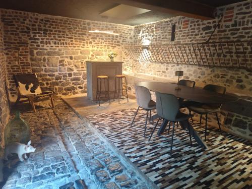 a room with a table and chairs and a fireplace at La Grange de Bonneville in Andenne