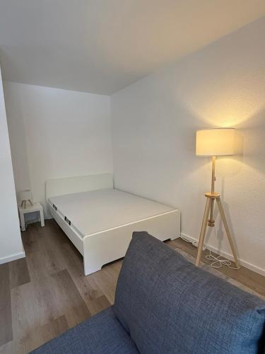 a bedroom with a white bed and a lamp at Frisch renoviertes Appartement in Mönchengladbach