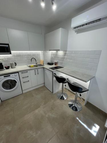 een witte keuken met een wastafel en een wasmachine bij Central Studio next to Metro in Piraeus