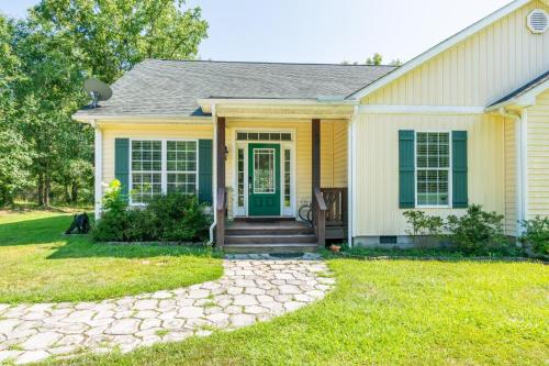 a house with a green door and a yard at Lakeside Villa Retreat 5-Bedroom Oasis with 6 TVs 3-Acres of Waterfront Fishing & Canoe Adventures in Harlem