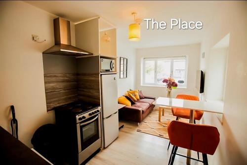 a kitchen with a stove and a table in a room at Hidden Kingston Vale-2 Bed in New Malden