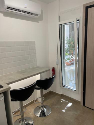 een keuken met een aanrecht en 2 krukken bij Central Studio next to Metro in Piraeus