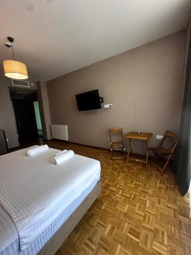 a hotel room with a bed and a table and a tv at Villa Sunlight in Gonio