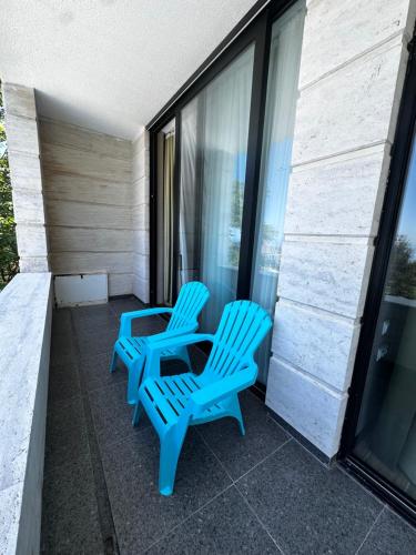 two blue chairs and a table on a balcony at Villa Sunlight in Gonio