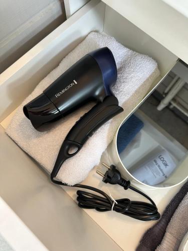 a black hairdryer in a box with a mirror at Cozy Kálfhóll in South Iceland in Hraunvellir