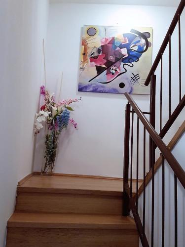 a staircase with a vase of flowers and a painting at Amarru Apartments in Piran