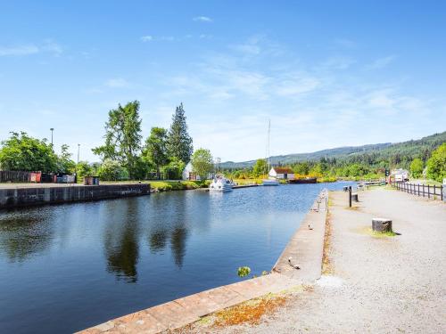 a river with a boat in the water at Lockview Upper Flat in Fort Augustus