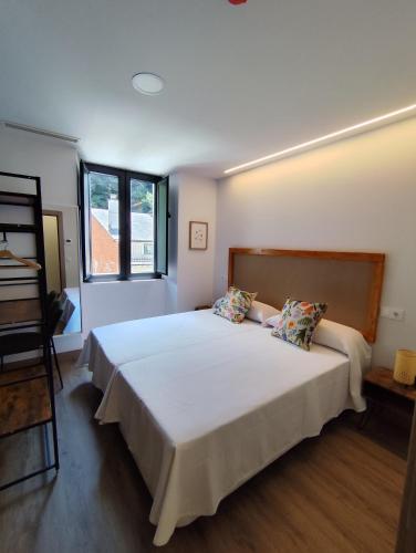 a bedroom with a large bed and a window at Hotel Casa dos Gardas in Samos