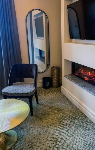 a living room with a mirror and a chair and a fireplace at Killarney Randles Hotel in Killarney