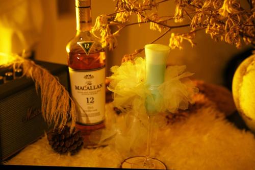 a bottle of alcohol sitting next to a wine glass at Lijiang Jijian Xiangwang SOOOAN Luxury Resort Hotel in Lijiang
