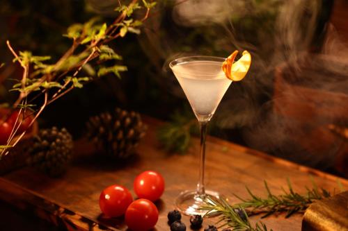 a drink in a glass sitting on a table with fruit at Lijiang Jijian Xiangwang SOOOAN Luxury Resort Hotel in Lijiang