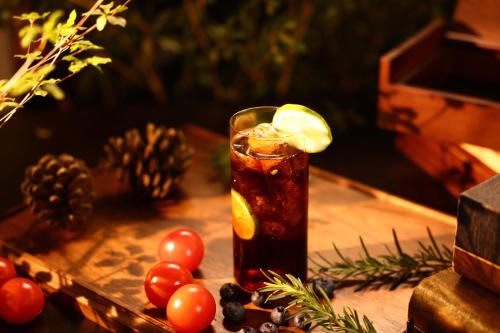 a drink in a glass with a lemon slice on a table at Lijiang Jijian Xiangwang SOOOAN Luxury Resort Hotel in Lijiang