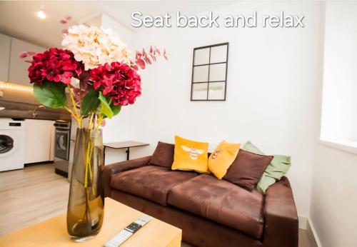 a vase with red and white flowers in a living room at Hidden Kingston Vale-2 Bed in New Malden