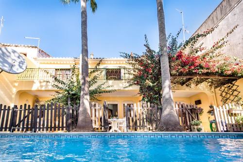a house with palm trees and a swimming pool at Casa Central in Tavira