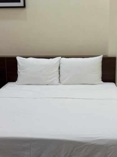 a bed with white sheets and pillows at Cao Bang Eco Bistro & Stay in Cao Bằng