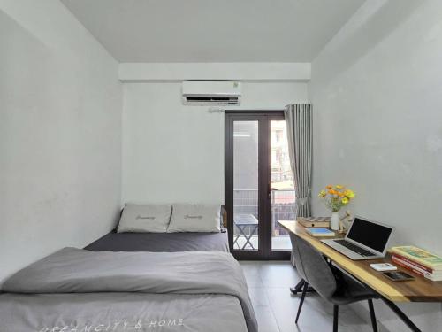a bedroom with a bed and a desk with a laptop at The Chilling'N Homestay Ha Noi 89 in Hanoi
