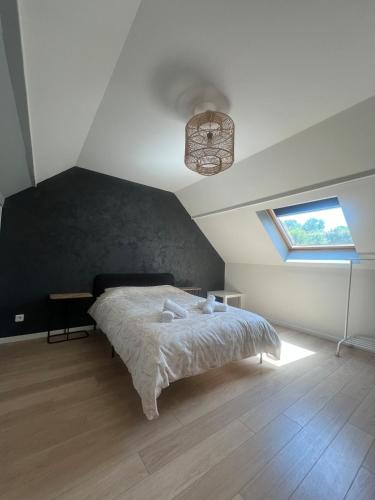 ein Schlafzimmer mit einem Bett und einem Fenster an der Decke in der Unterkunft Maison à 5 min de Disneyland Paris in Esbly