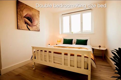 a bedroom with a bed and a window at Hidden Kingston Vale-2 Bed in New Malden