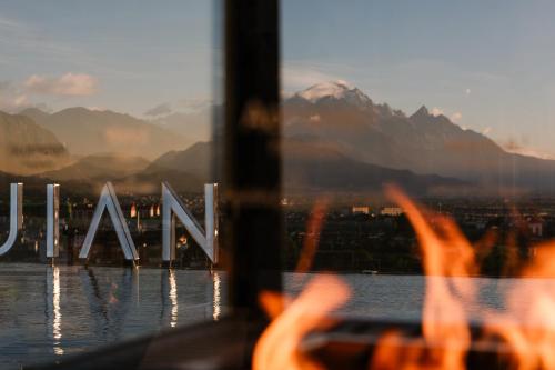 a person is looking out of a window at the mountains at Lijiang Jijian Xiangwang SOOOAN Luxury Resort Hotel in Lijiang