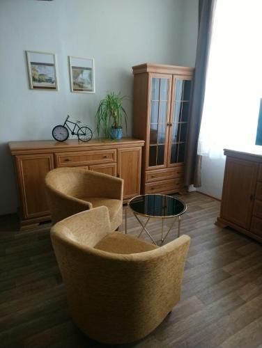 a living room with two chairs and a table at Apartman TGMasaryka in Karlovy Vary