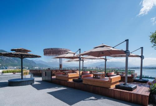 a restaurant with tables and umbrellas on a patio at Lijiang Jijian Xiangwang SOOOAN Luxury Resort Hotel in Lijiang