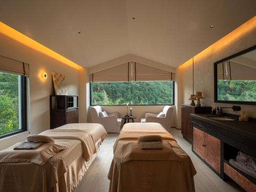 a hotel room with two beds and a television at Lijiang Jijian Xiangwang SOOOAN Luxury Resort Hotel in Lijiang