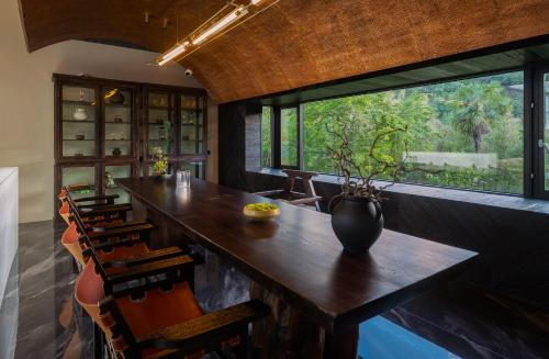 a dining room with a large window and a wooden table at Lijiang Jijian Xiangwang SOOOAN Luxury Resort Hotel in Lijiang