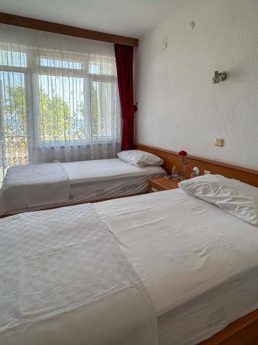 two beds in a bedroom with a window at Anamur Nice Hotel in Anamur