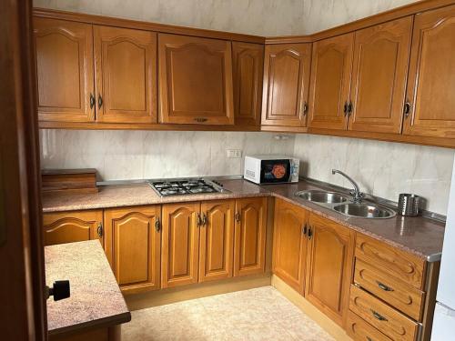 a kitchen with wooden cabinets and a sink at La buganvilla dell Torcal in Villanueva de la Concepción