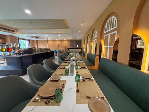 a long dining room with long tables and chairs at Anandi Bhawan by Paandora in Chhatikara