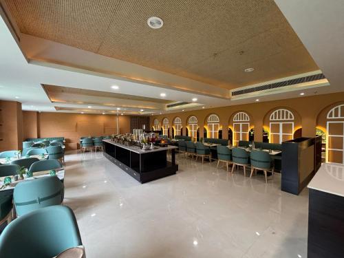 a dining room with chairs and a bar in it at Anandi Bhawan by Paandora in Chhatikara
