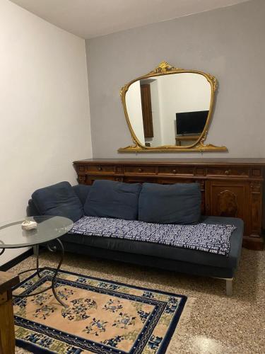 a living room with a blue couch and a mirror at Virginia in Montecatini Alto