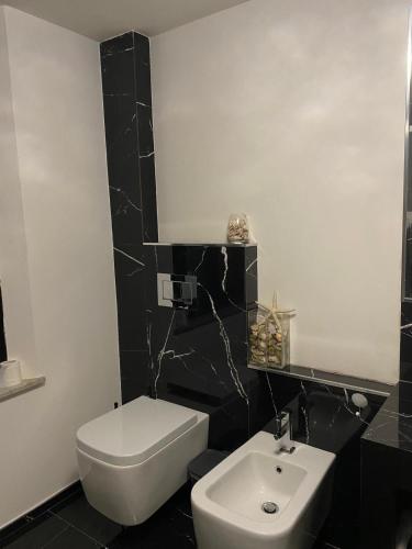a black and white bathroom with a toilet and a sink at Virginia in Montecatini Alto