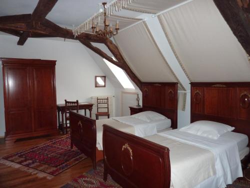 een slaapkamer met 2 bedden en een tafel in een kamer bij Chateau-Gaillard in Corbelin