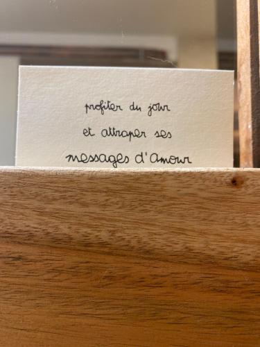 a piece of paper on top of a wooden drawer at Les Carillons du Bois de l'Orme in Les Pechs-du-Vers
