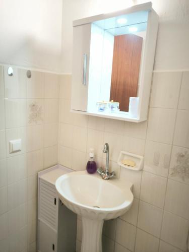 a bathroom with a sink and a mirror at Kinira Seaside House in Koinyra