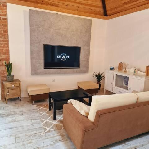 a living room with a couch and a tv on the wall at Loft beach in Vieira de Leiria