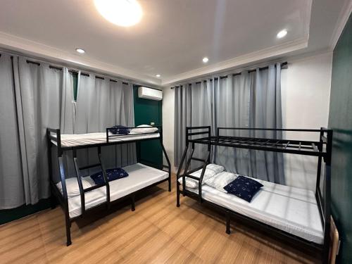 two bunk beds are in a room with curtains at Poolside Cottage in Lubao