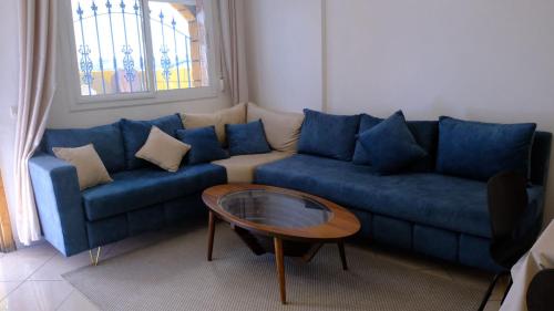 a living room with a blue couch and a table at Beachhouse Asilah in Asilah