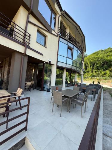 a patio with tables and chairs in front of a building at Vila Premiere Bistro-Spa in Piatra Neamţ