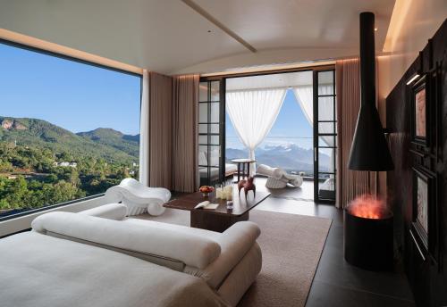 a bedroom with a large bed and a large window at Lijiang Jijian Xiangwang SOOOAN Luxury Resort Hotel in Lijiang
