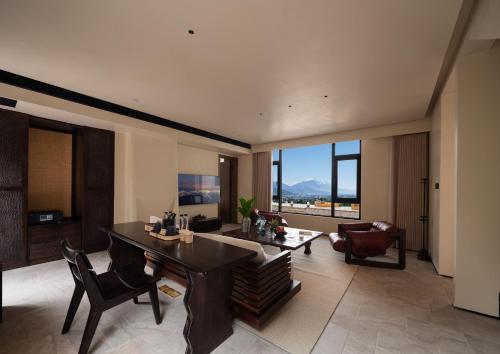 a living room with a table and a couch at Lijiang Jijian Xiangwang SOOOAN Luxury Resort Hotel in Lijiang