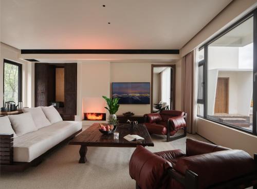 a living room with a couch and a table at Lijiang Jijian Xiangwang SOOOAN Luxury Resort Hotel in Lijiang