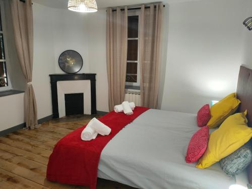 a bedroom with a large bed with red and yellow pillows at Nid cosy face à la Cathedrale in Saint-Flour