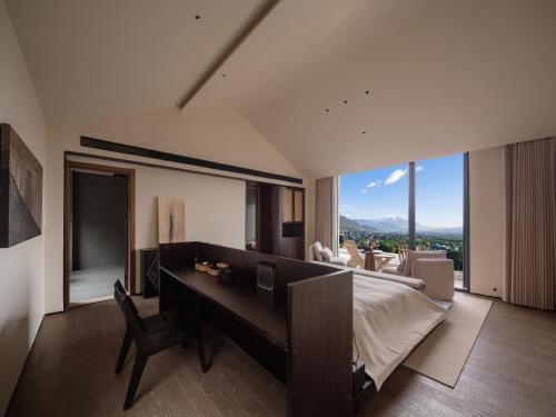 a bedroom with a piano and a room with a view at Lijiang Jijian Xiangwang SOOOAN Luxury Resort Hotel in Lijiang