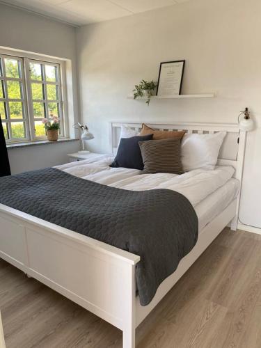 a large white bed in a white bedroom at Svalereden Strand Camping Apartments in Frederikshavn