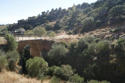 a bridge over a mountain with trees and bushes at La buganvilla dell Torcal in Villanueva de la Concepción