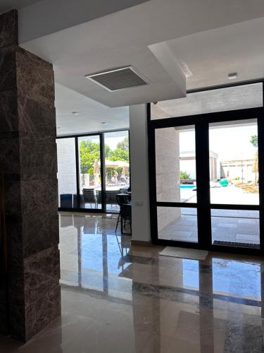 an empty room with glass doors and a lobby at Villa Sunlight in Gonio