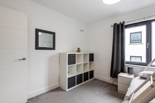a white bedroom with a bed and a window at Portrush Family Stay By The Beach 